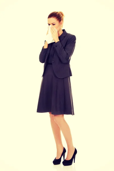 Businesswoman with sneezing into tissue. — Stock Photo, Image