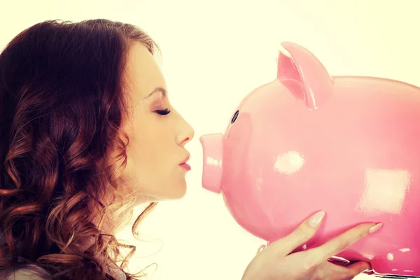 Business woman kissing a piggybank. — Stock Photo, Image