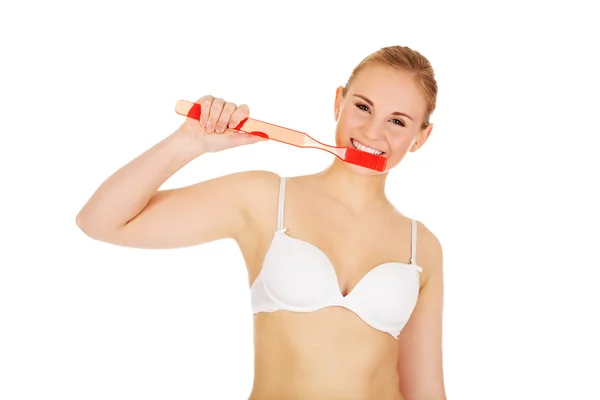 女性の巨大な歯ブラシで歯を磨いたり — ストック写真
