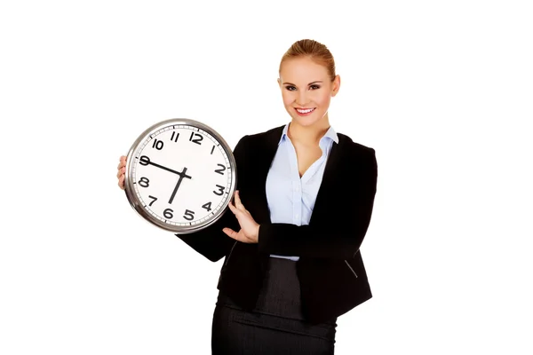 Smiling young business woman holding office clock — Stock Photo, Image