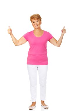 Başparmak yukarıya ile yaşlı bir smilig kadın