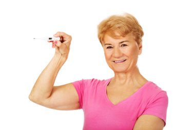 Gülümseyen yaşlı kadın termometre gösteriyor.