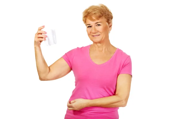 Gülümseyen kadın kıdemli bir diş model holding — Stok fotoğraf