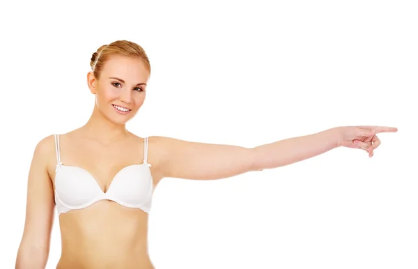 Young woman in white bra pointing for copyspace or something — Stock Photo, Image