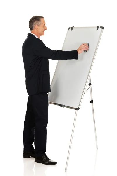 Masculino executivo limpeza um flip chart — Fotografia de Stock