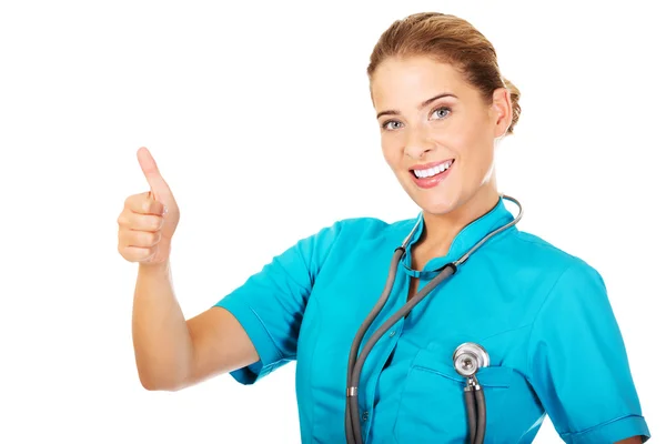 Young female doctor or nurse with stethocope shows thumb up — Stock Photo, Image