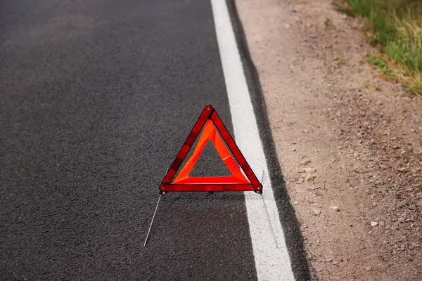 Un triangle d'avertissement rouge sur une route — Photo