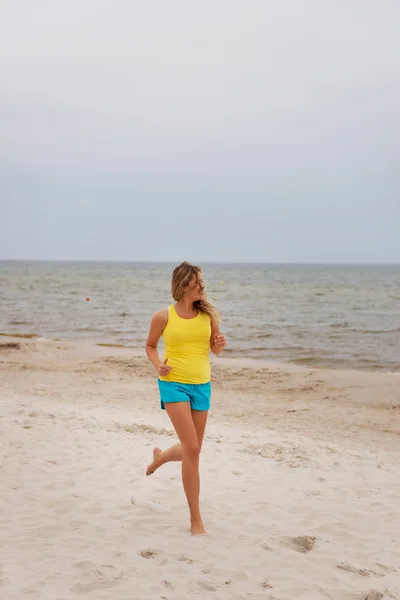 Young woman running on the beach — Stock Photo, Image