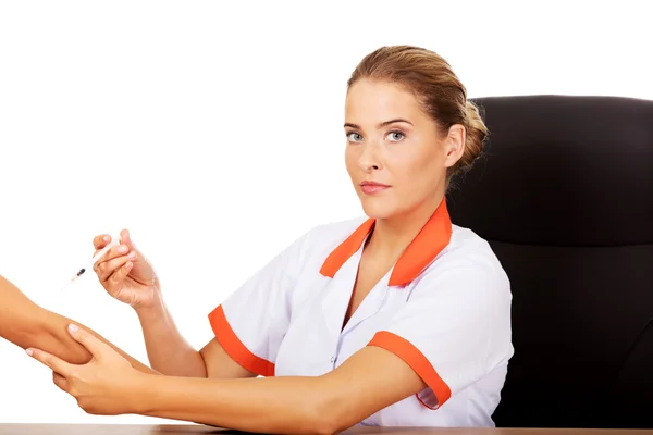 Young female doctor or nurse giving an injection — Stock Photo, Image