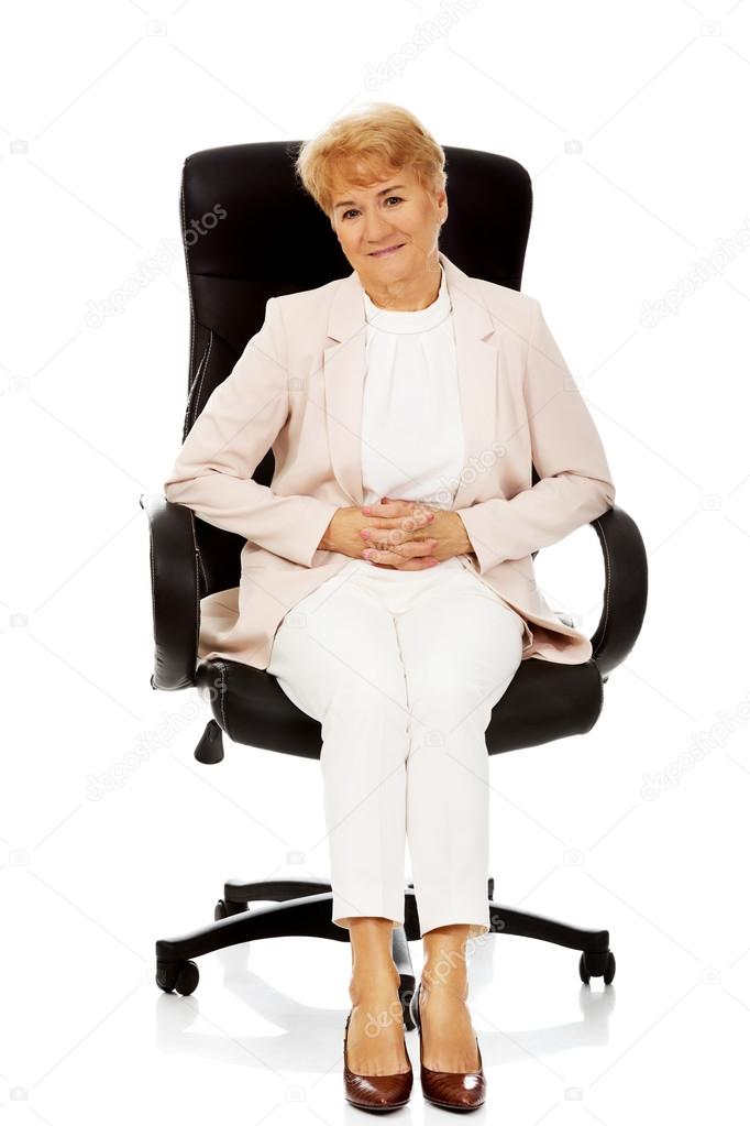 Smile elderly business woman sitting on armchair