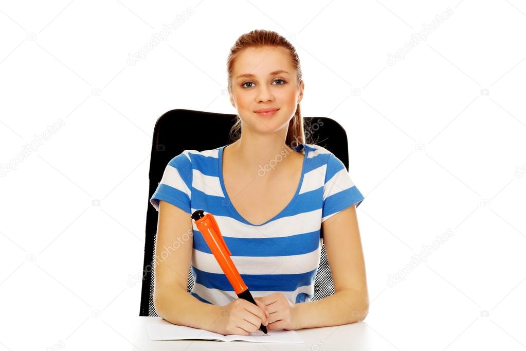 Teenage woman doing notes with a huge pen
