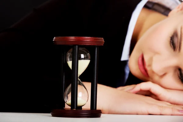 Jonge zakenvrouw slapen op het Bureau met zandloper — Stockfoto