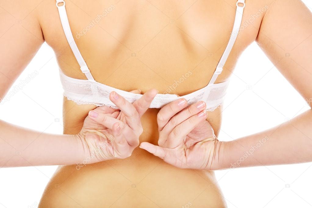 Young woman unbuttons her bra