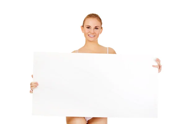 Sexy young woman holding empty board — Stock Photo, Image