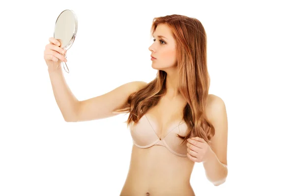 Μια νεαρή όμορφη γυναίκα κοιτάζεται στον καθρέφτη. — Φωτογραφία Αρχείου