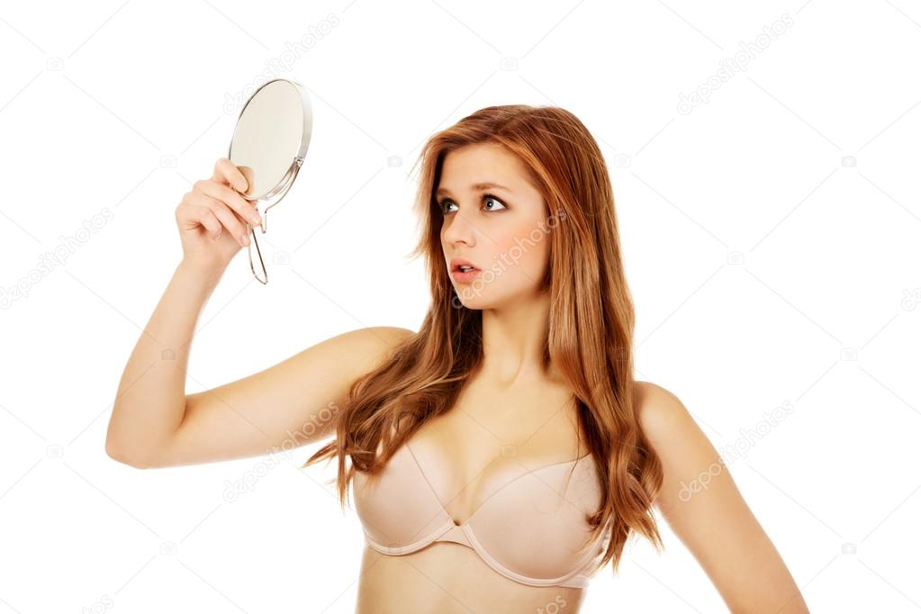 Beautiful shocked woman with a mirror