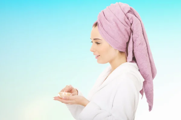 Woman in bathrobe with cream moisturizer. — Stock Photo, Image