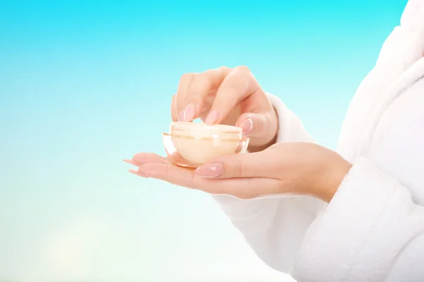 Woman in bathrobe with cream moisturizer. — Stock Photo, Image