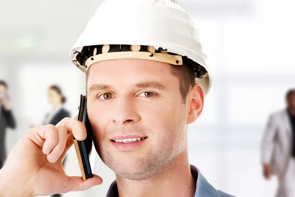 Bauunternehmer in Hardhatgesprächen auf seinem Handy. — Stockfoto