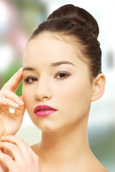 Mujer con maquillaje completo tocando la cara . —  Fotos de Stock