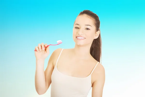 Jonge vrouw bedrijf tandenborstel. — Stockfoto