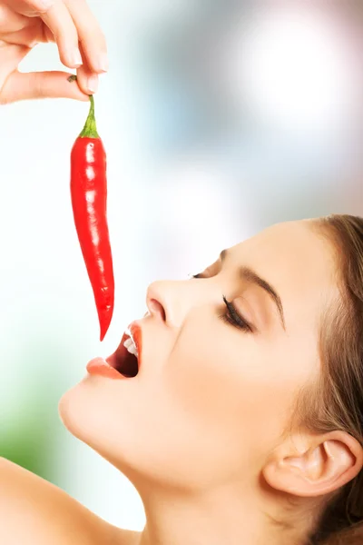 Portrait of nude woman eating chilli — Stock Photo, Image