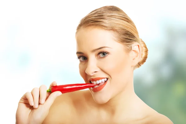 Happy nude woman eating chilli, looking at the camera — Stock Photo, Image