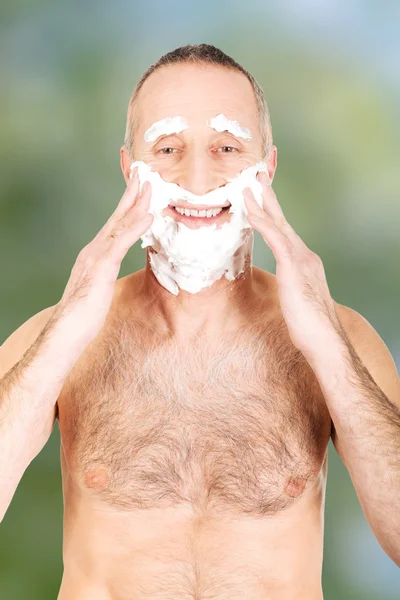 Homem aplicando espuma de barbear — Fotografia de Stock