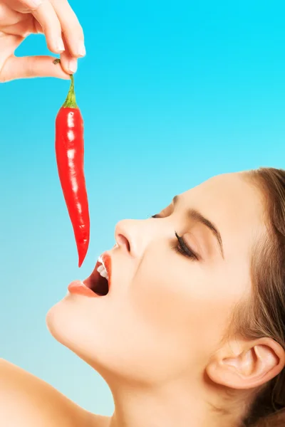 Portrait of nude woman eating chilli Royalty Free Stock Photos