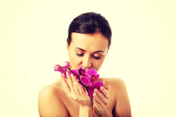 Oben ohne Frau mit lila Orchideenzweig — Stockfoto