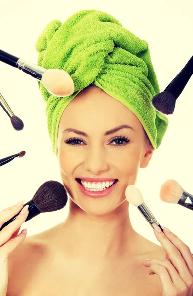 Young woman has brushes around face. — Stock Photo, Image