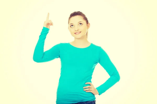 Mujer joven sonriente señalando hacia arriba. —  Fotos de Stock