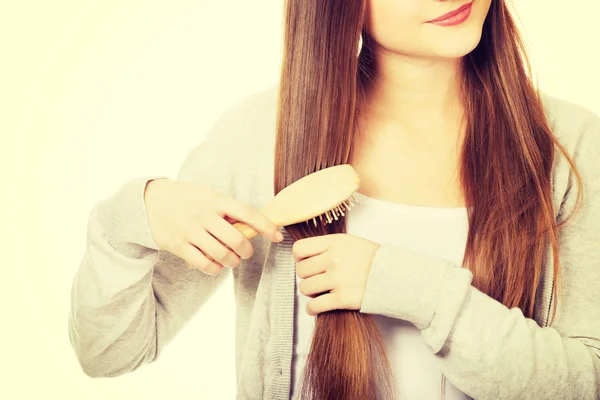 Mulher adolescente escovando o cabelo . — Fotografia de Stock