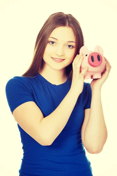 Tonåriga kvinna anläggning piggybank. — Stockfoto