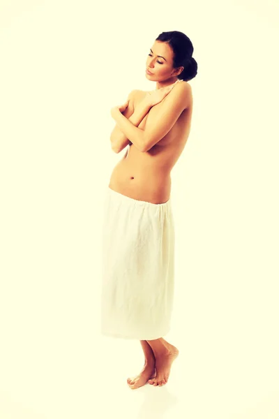 Woman standing wrapped in towel — Stock Photo, Image