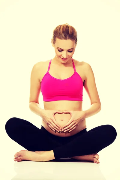 Mulher grávida sentado cruz pernas — Fotografia de Stock