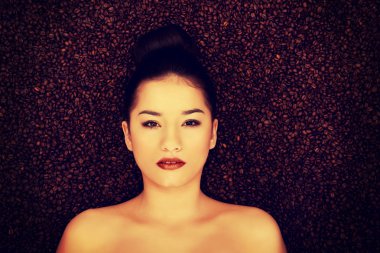 çekici kadın kahve taneleri içinde yalan.