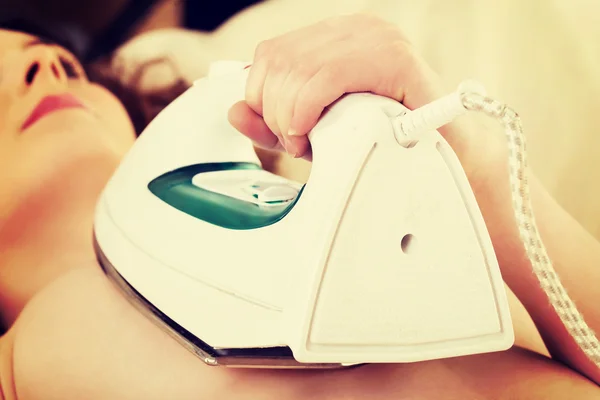 Woman with iron on her breast. — Stock Photo, Image