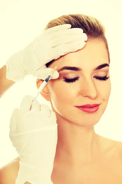 Junge lächelnde Frau bekommt Botox ins Gesicht gespritzt. — Stockfoto