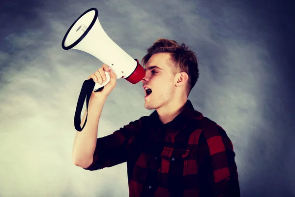 Young man shouting in megaphone. — Stock Photo, Image