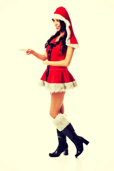 Mulher usando roupas de Papai Noel apontar — Fotografia de Stock