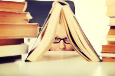 Genç kadın bir kitap saklanıyor