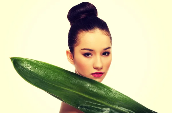 Schöne Frau mit grünem Blatt. — Stockfoto