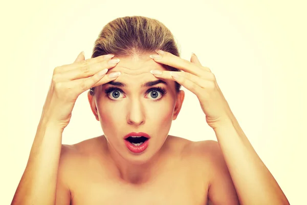 Young woman checking wrinkles on her forehead — Stock Photo, Image