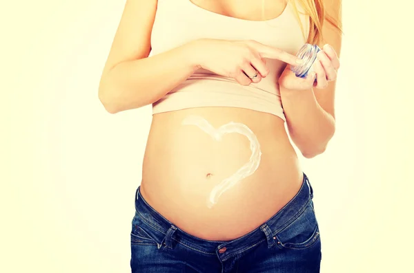 Pregnant woman applying cream on her belly — Stock Photo, Image