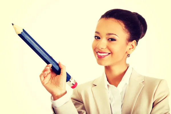 Businesswoman pointing up with big pencil. — Stock Photo, Image