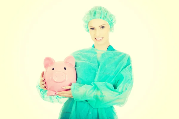 Női orvos rózsaszín malacka bank. — Stock Fotó