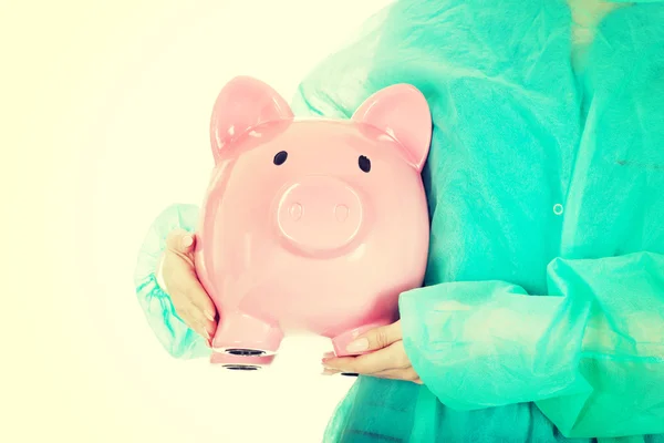 Médico femenino con alcancía rosa . — Foto de Stock