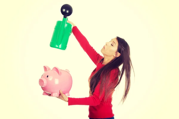 Woman watering piggybank. — Stock Photo, Image