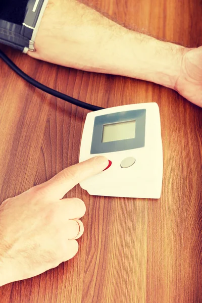 Hombre revisando su presión arterial en casa — Foto de Stock